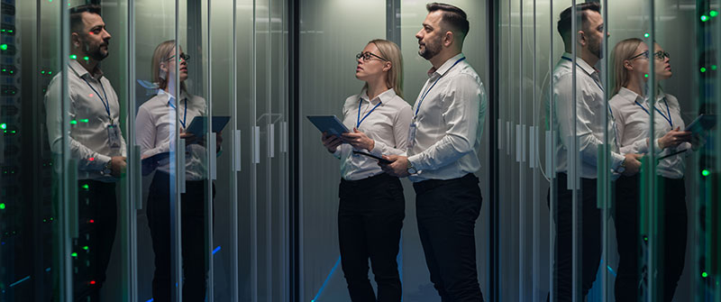 workers-in-a-data-center-walking-between-rows-of-server-racks